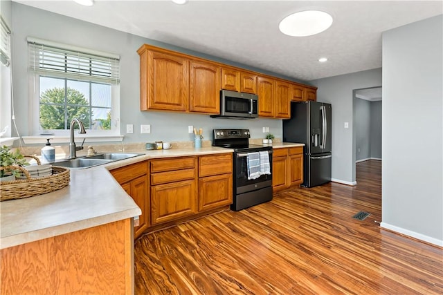 2000 Michael Dr, Baldwin Boro, PA 15227 - kitchen featuring black appliances, a sink, dark wood-style flooring, brown cabinets, and light countertops