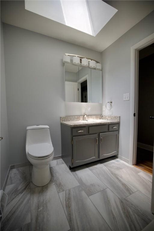 906 Arch Ave, Castle Shannon, PA 15234 - bathroom with a skylight, vanity, toilet, and baseboards