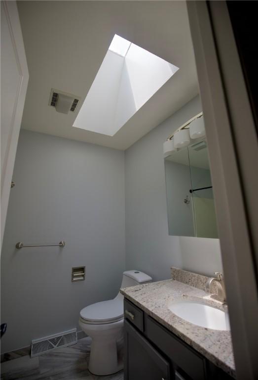 906 Arch Ave, Castle Shannon, PA 15234 - bathroom featuring a skylight, vanity, and toilet
