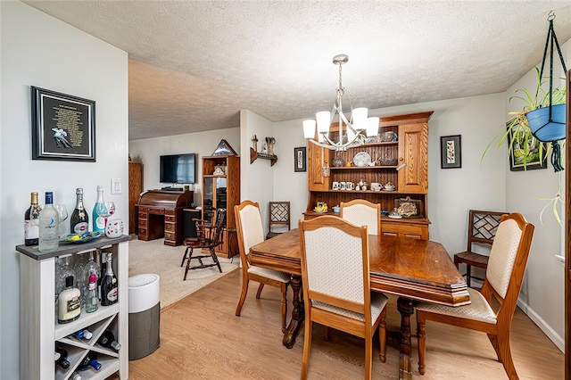 204 Fosterville Rd, Hempfield Twp Wml, PA 15601 - dining room featuring a chandelier, light wood finished floors, and a textured ceiling