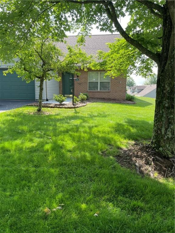 206 Saddlebrook Dr, White Twp Ind, PA 15701 - view of property hidden behind natural elements featuring brick siding, driveway, a front lawn, and a garage