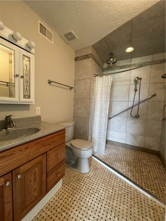 206 Saddlebrook Dr, White Twp Ind, PA 15701 - full bathroom featuring tiled shower, vanity, toilet, and a textured ceiling