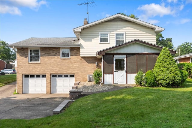 216 Bainbridge Dr, Center Twp Bea, PA 15001 - back of house featuring a sunroom, concrete driveway, a garage, brick siding, and a lawn