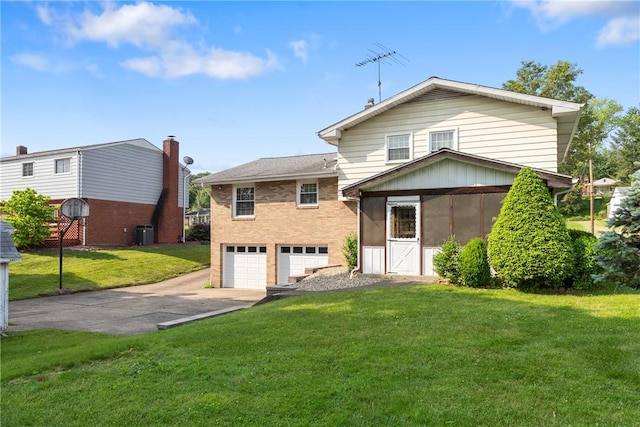 216 Bainbridge Dr, Center Twp Bea, PA 15001 - rear view of property featuring driveway, a garage, central AC unit, a lawn, and a sunroom