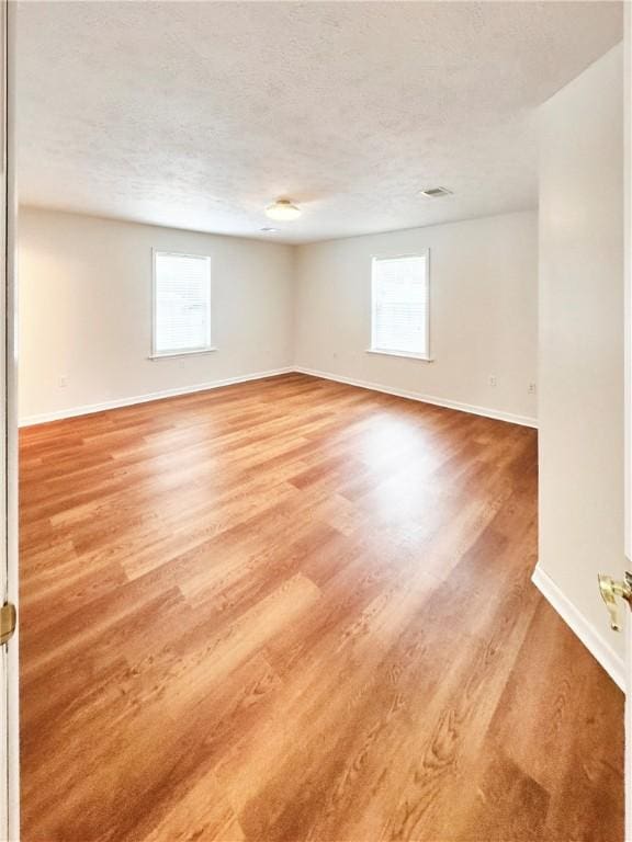 121 Columbus Dr, Punxsutawney Area School District, PA 15767 - empty room featuring baseboards, light wood-style flooring, and a textured ceiling
