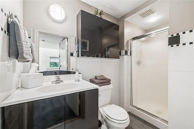 340 Lakewood Rd, Unity Twp, PA 15601 - bathroom with toilet, a shower stall, vanity, and tile walls