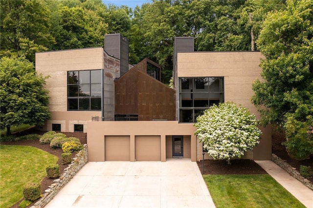 340 Lakewood Rd, Unity Twp, PA 15601 - modern home featuring driveway, a garage, a front yard, and stucco siding