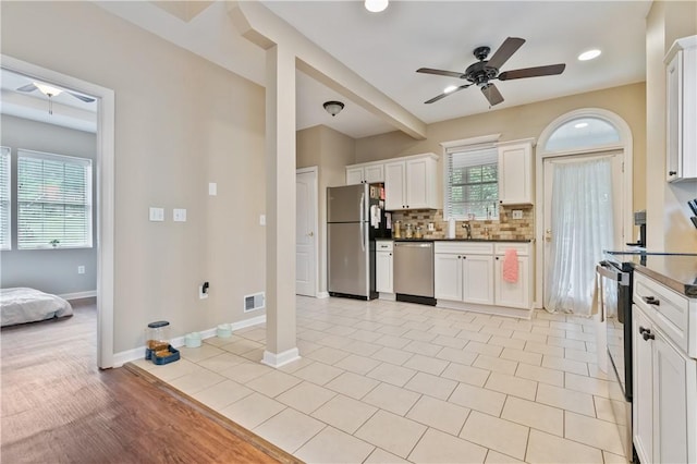 1503 Kenberma Ave, Beechview, PA 15216 - kitchen with appliances with stainless steel finishes, ceiling fan, a sink, decorative backsplash, and white cabinetry