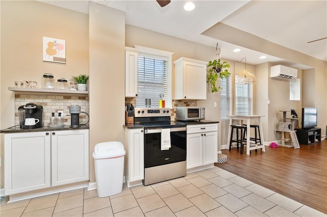 1503 Kenberma Ave, Beechview, PA 15216 - kitchen with stainless steel appliances, light tile patterned floors, backsplash, a wall unit AC, and recessed lighting