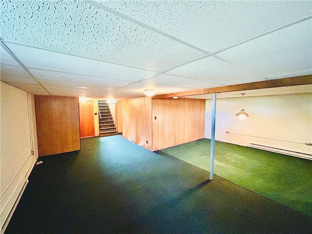 7 Windridge Dr, Uniontown, PA 15401 - finished below grade area featuring stairs, a baseboard radiator, a drop ceiling, and wooden walls