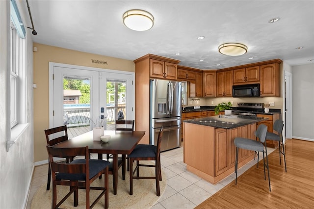 3315 Crestview Dr N, Versailles, PA 15137 - kitchen with appliances with stainless steel finishes, french doors, a kitchen island, baseboards, and brown cabinets