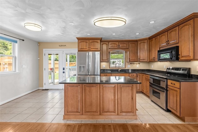 3315 Crestview Dr N, Versailles, PA 15137 - kitchen with appliances with stainless steel finishes, a sink, a kitchen island, light tile patterned floors, and recessed lighting