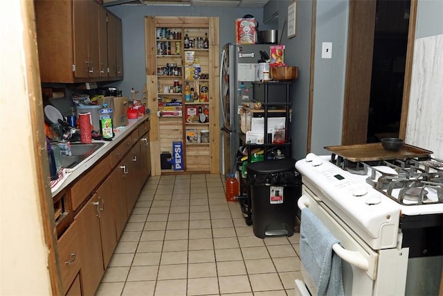 5 Moyer Ave, Scottdale, PA 15683 - kitchen featuring white range, light tile patterned flooring, a sink, and light countertops