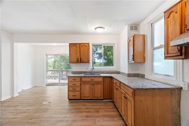 1567 Princeton Blvd, Wilkinsburg, PA 15221 - kitchen featuring a sink, stone countertops, brown cabinets, and plenty of natural light