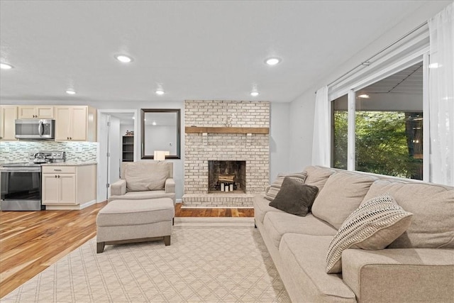 259 Old Blackhawk Rd, Chippewa Twp, PA 15010 - living room with light wood-type flooring, a brick fireplace, and recessed lighting