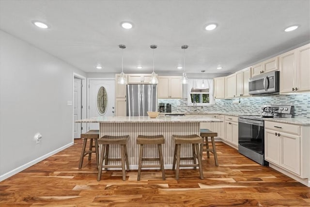 259 Old Blackhawk Rd, Chippewa Twp, PA 15010 - kitchen featuring appliances with stainless steel finishes, a kitchen island, backsplash, a breakfast bar, and light wood finished floors