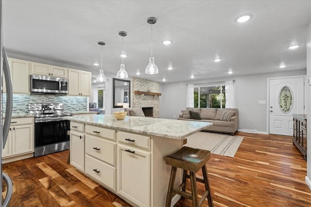 259 Old Blackhawk Rd, Chippewa Twp, PA 15010 - kitchen with appliances with stainless steel finishes, wood finished floors, recessed lighting, a kitchen island, and a brick fireplace