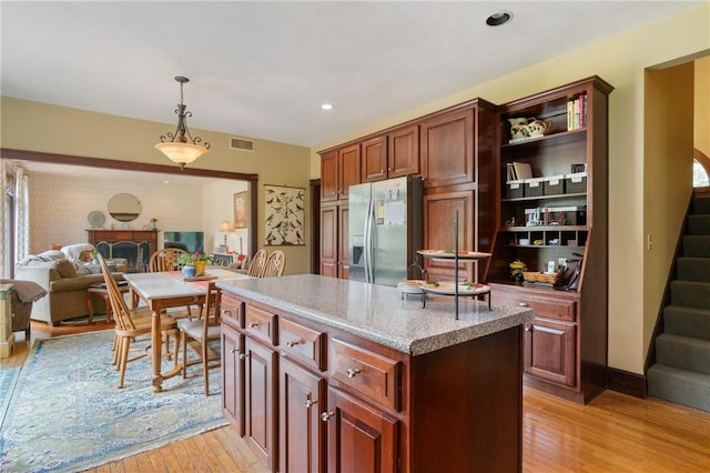 26 Indian Fields Trl, Lower Burrell, PA 15068 - kitchen featuring stainless steel refrigerator with ice dispenser, light wood finished floors, hanging light fixtures, open floor plan, and a kitchen island