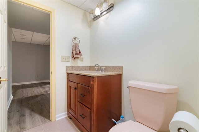 26 Indian Fields Trl, Lower Burrell, PA 15068 - half bathroom featuring a paneled ceiling, toilet, vanity, baseboards, and tile patterned floors