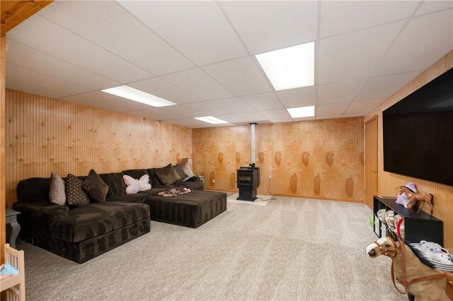 258 Smith Rd, Connoquenessing Twp, PA 16053 - living room featuring a wood stove, carpet, a paneled ceiling, and wooden walls