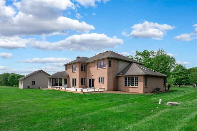 258 Smith Rd, Connoquenessing Twp, PA 16053 - rear view of house featuring a patio area, brick siding, a lawn, and a sunroom