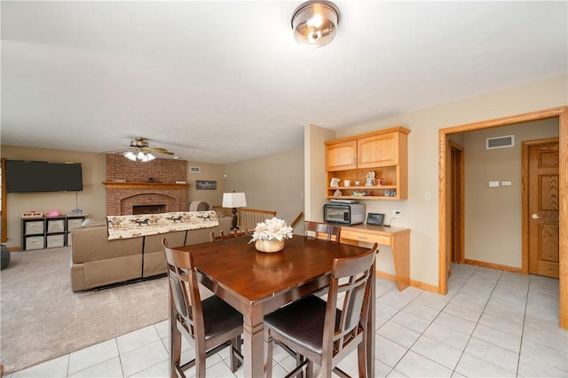 258 Smith Rd, Connoquenessing Twp, PA 16053 - dining space featuring a ceiling fan, light tile patterned floors, a brick fireplace, and baseboards