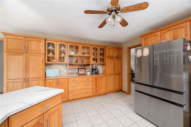 258 Smith Rd, Connoquenessing Twp, PA 16053 - kitchen with freestanding refrigerator, light countertops, backsplash, glass insert cabinets, and brown cabinets