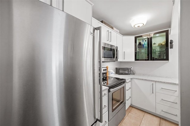 3266 Ward St Unit 8, Oakland, PA 15213 - kitchen featuring appliances with stainless steel finishes, light tile patterned floors, white cabinets, light stone countertops, and decorative backsplash