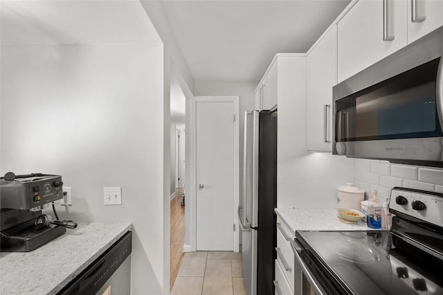 3266 Ward St Unit 8, Oakland, PA 15213 - kitchen with appliances with stainless steel finishes, white cabinetry, backsplash, light tile patterned floors, and light stone counters