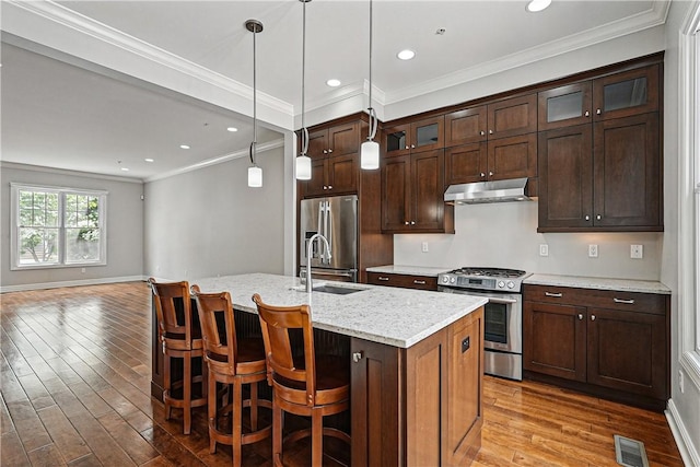 1621 Overton Ln, Squirrel Hill, PA 15217 - kitchen featuring appliances with stainless steel finishes, under cabinet range hood, a sink, wood finished floors, and an island with sink