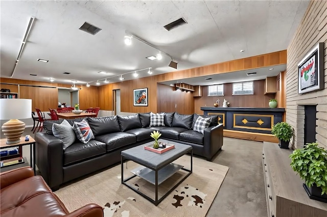 194 Southvue Dr, Whitehall, PA 15236 - living room featuring rail lighting, wooden walls, finished concrete floors, and a fireplace