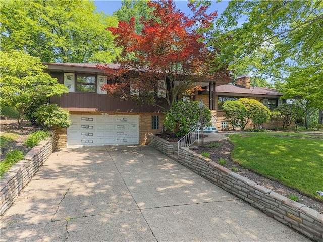 194 Southvue Dr, Whitehall, PA 15236 - view of front of property with an attached garage, concrete driveway, a front lawn, a chimney, and stone siding