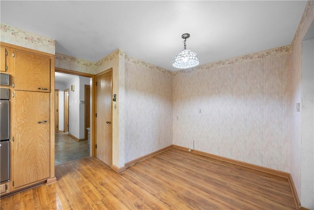 194 Southvue Dr, Whitehall, PA 15236 - unfurnished dining area with wallpapered walls, light wood finished floors, and baseboards