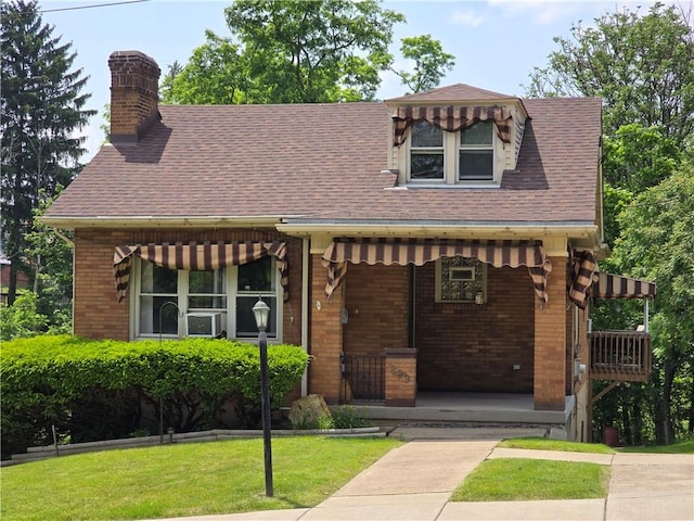 229 Bluff St, Canonsburg, PA 15317 - view of front of property featuring brick siding, a chimney, a porch, a front lawn, and roof with shingles
