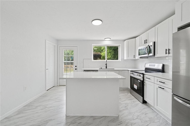 1004 Government Rd, Penn Twp Wml, PA 15642 - kitchen featuring appliances with stainless steel finishes, a sink, tasteful backsplash, a kitchen island, and light countertops