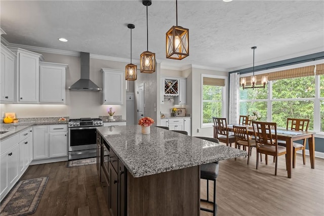 582 Forest Oaks Trl, North Huntingdon, PA 15642 - kitchen featuring wall chimney range hood, stainless steel gas range oven, dark wood-style floors, a chandelier, and crown molding