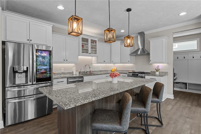 582 Forest Oaks Trl, North Huntingdon, PA 15642 - kitchen featuring stainless steel appliances, wall chimney exhaust hood, a sink, a center island, and white cabinets