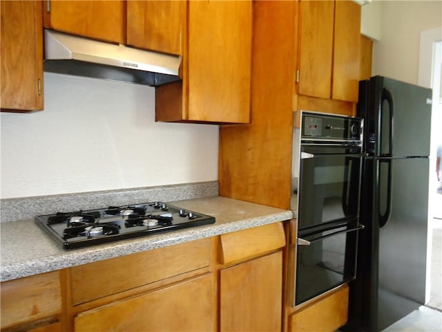 30 Coulter St, Crafton, PA 15205 - kitchen with under cabinet range hood, black appliances, light countertops, and brown cabinetry