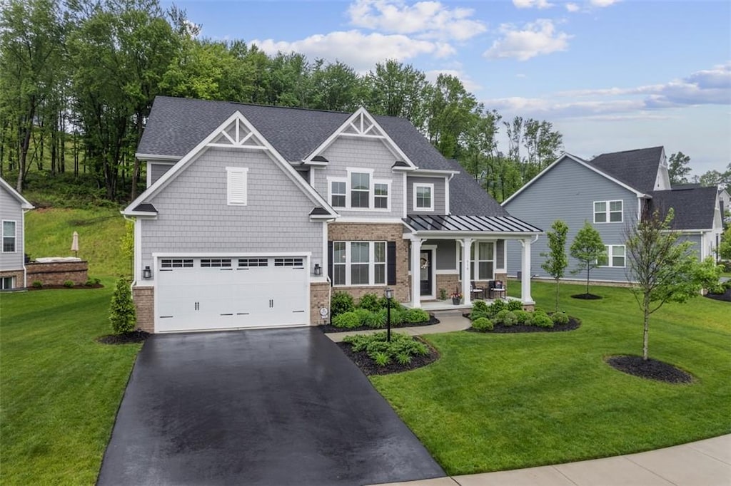 318 Crest Ln, Adams Twp, PA 16046 - craftsman-style house featuring covered porch, asphalt driveway, a garage, a front yard, and a standing seam roof