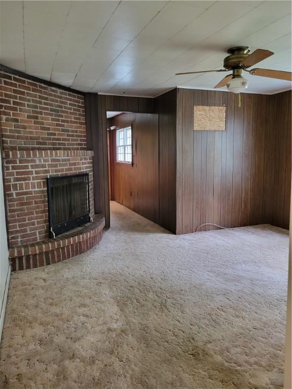 36 Daisytown Rd, Centerville, PA 15427 - unfurnished living room featuring carpet floors, a fireplace, a ceiling fan, and wooden walls