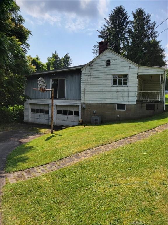 36 Daisytown Rd, Centerville, PA 15427 - view of front of home featuring a chimney, asphalt driveway, a front yard, an attached garage, and central AC
