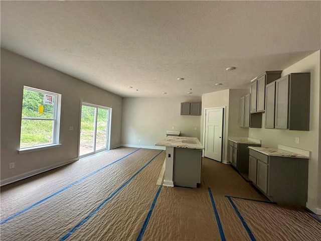 3045 Audrey Dr, Hempfield Twp, PA 15601 - kitchen featuring gray cabinetry, a kitchen island, a textured ceiling, open floor plan, and recessed lighting