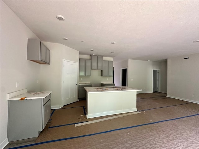 3045 Audrey Dr, Hempfield Twp, PA 15601 - kitchen featuring gray cabinets, a kitchen island, and a textured ceiling
