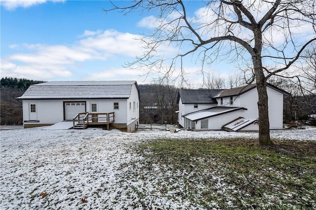 155 Old E Butler Rd, Summit Twp But, PA 16002 - snow covered back of property featuring a wooden deck and a garage