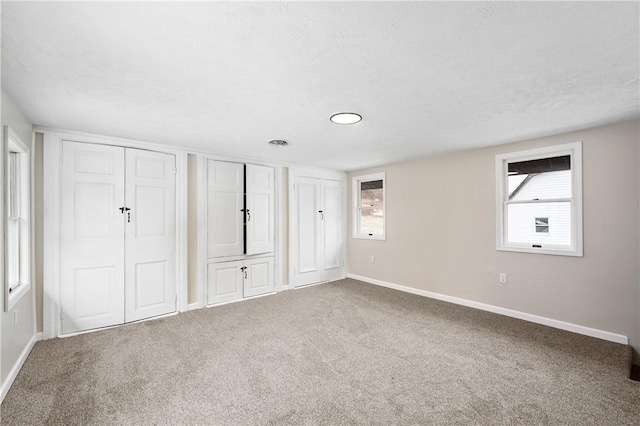 155 Old E Butler Rd, Summit Twp But, PA 16002 - unfurnished bedroom featuring two closets, baseboards, carpet, and a textured ceiling