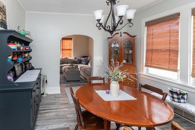 124 Clarendon Ave, South Union Twp, PA 15401 - dining area with arched walkways, a chandelier, light wood-style floors, ornamental molding, and baseboards