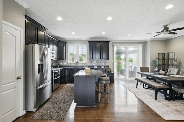 228 Eagle Dr, Cranberry Twp, PA 16066 - kitchen featuring stainless steel appliances, crown molding, a kitchen island, stone counters, and a kitchen bar