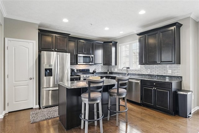 228 Eagle Dr, Cranberry Twp, PA 16066 - kitchen with stainless steel appliances, dark wood-type flooring, a center island, a breakfast bar area, and crown molding