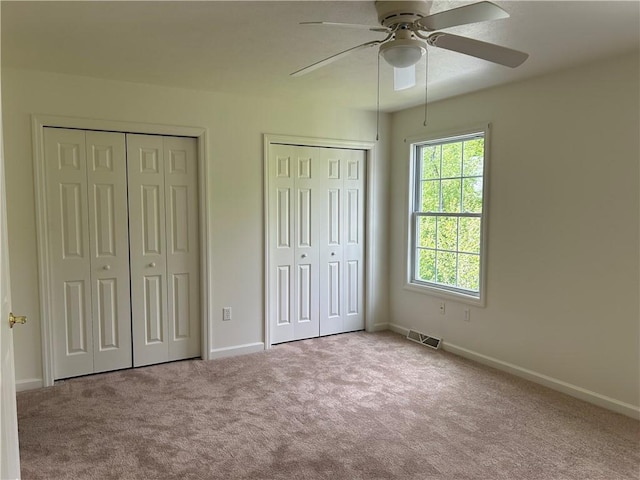 607 Crestview Ln, Lower Burrell, PA 15068 - unfurnished bedroom featuring two closets, carpet floors, baseboards, and a ceiling fan