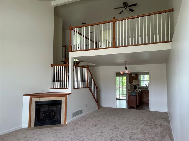 607 Crestview Ln, Lower Burrell, PA 15068 - unfurnished living room with carpet flooring, ceiling fan, a towering ceiling, baseboards, and a chandelier